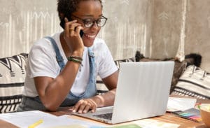 Responsable de communication au téléphone devant un ordinateur portable et des documents