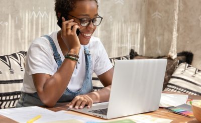 Responsable de communication au téléphone devant un ordinateur portable et des documents