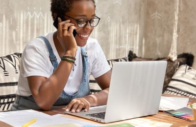 Responsable de communication au téléphone devant un ordinateur portable et des documents