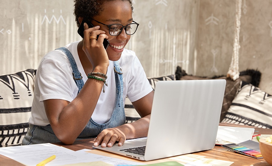 Responsable de communication au téléphone devant un ordinateur portable et des documents